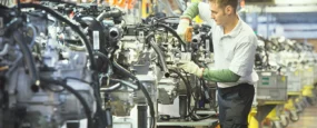 A man working on engines in a car production factory