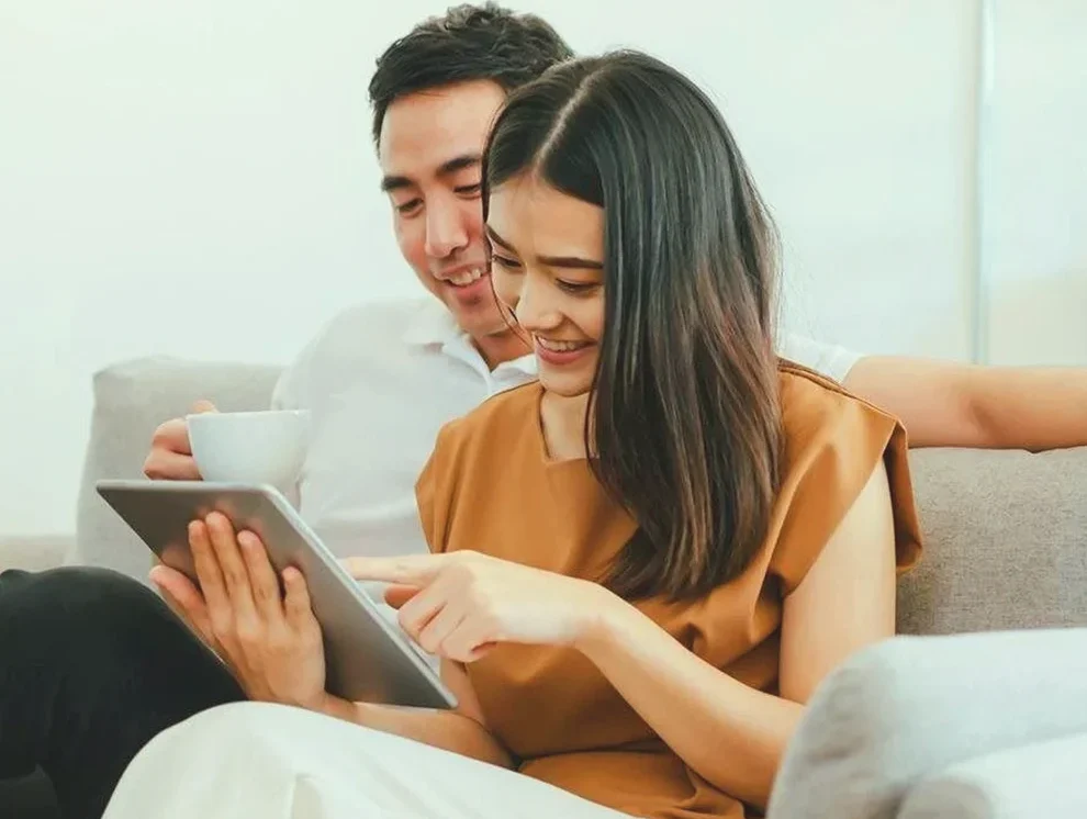 Couple reviewing finances on a tablet at home
